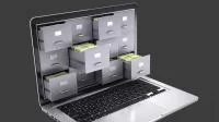 Digitales Archiv: Bild besteht aus einer Kombination aus Schubladen und Laptop.