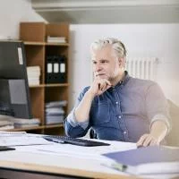 Ein Mann (Ingenieur) sitzt am Schreibtisch und arbeitet.