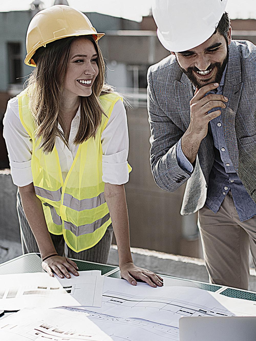 3 Verantwortliche arbeiten auf der Baustelle zusammen.