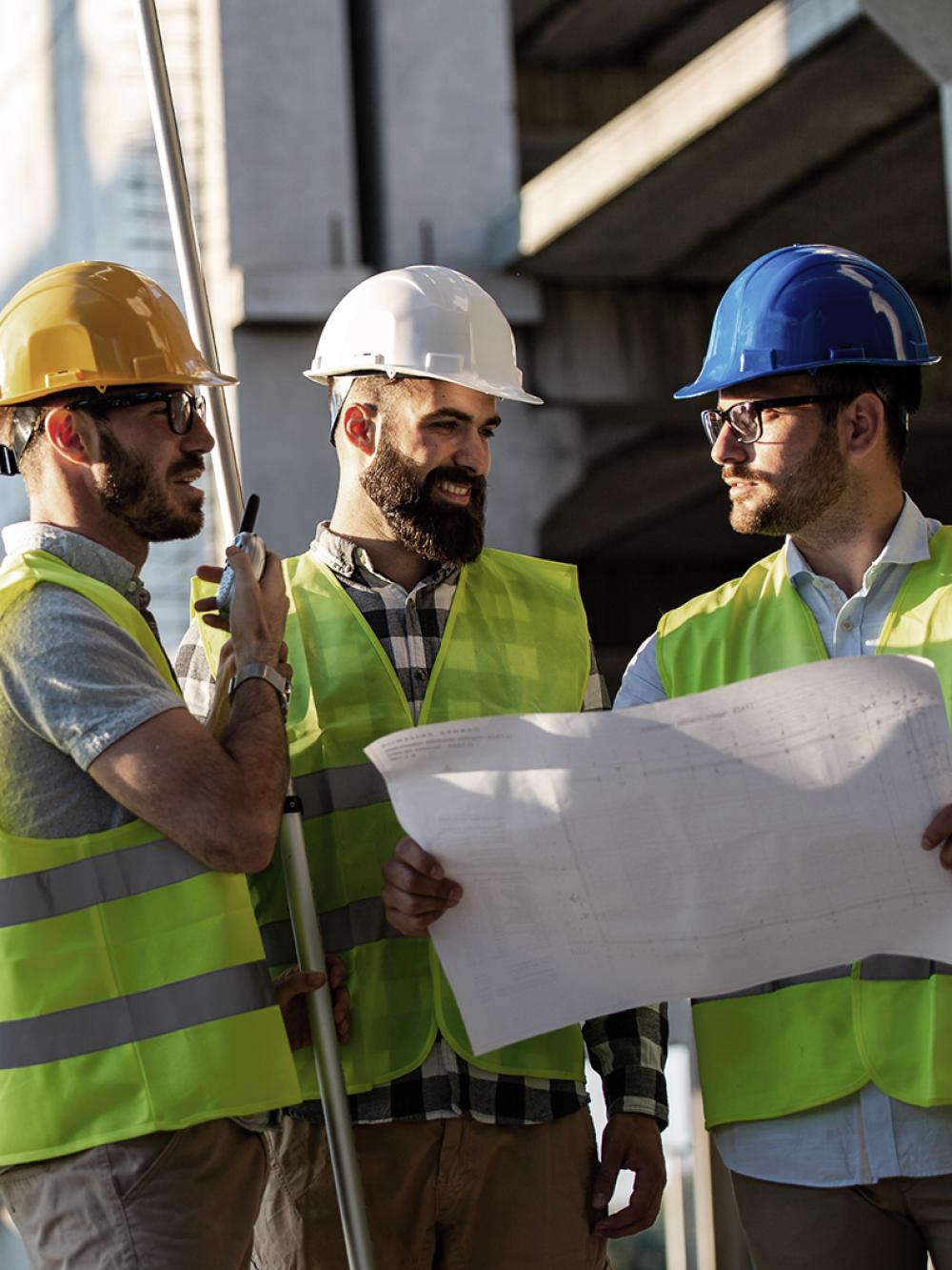 3 Herren auf der Baustelle arbeiten zusammen.