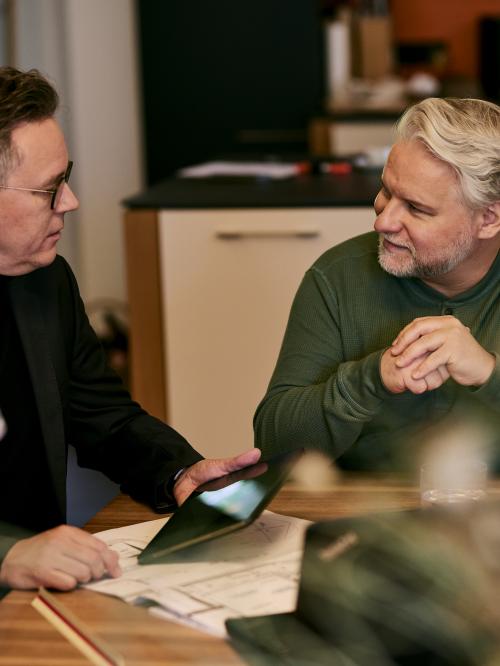 Drei Geschäftspartner sitzen am Tisch.