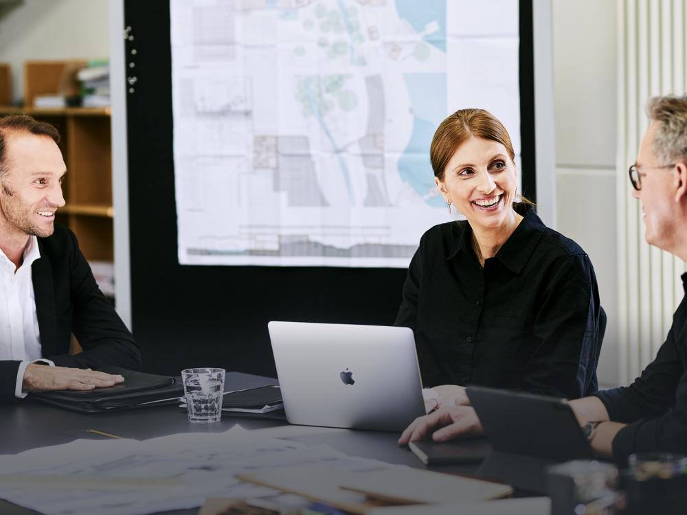 Kollegen zwei Architekten und eine Architektin unterhalten sich im Büro.