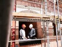 2 Personen auf der Baustelle in einem Haus. 