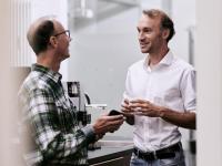 Zwei Personen tauschen sich an der Kaffeetheke aus.