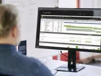 Bildschirm mit offener Software von PROJEKT PRO, davor sitzt ein Mann mit dem Rücken zum Betrachter.