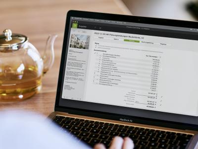 Notebook und daneben steht eine Teekanne.